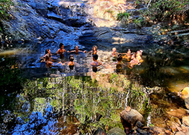 Friends swimming in lake within forest